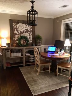 a table with two laptops sitting on top of it next to a lamp and window