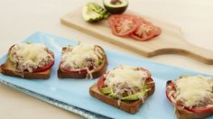 four open faced sandwiches on a blue plate