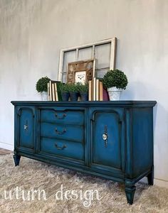 a blue dresser with books and plants on top