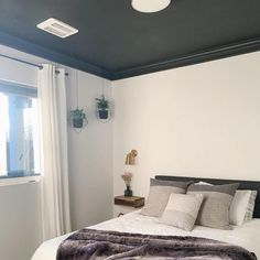 a bedroom with white walls and grey bedding