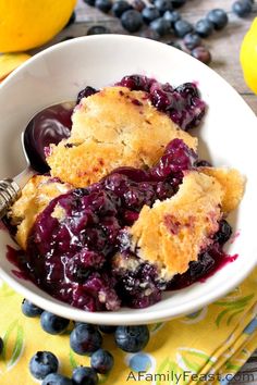 a white bowl filled with blueberry cobbler on top of a table