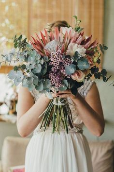 a woman holding a bouquet of flowers in her hands