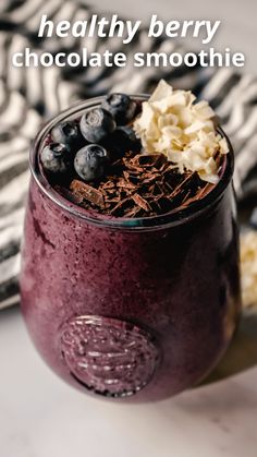 blueberry smoothie in a glass topped with chocolate and whipped cream