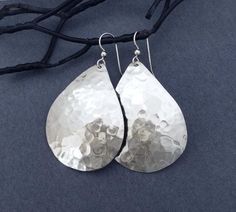 These artisan handmade large teardrop earrings are so versatile, they complement your favorite party dress, a casual weekend outfit and everything in between.  Sterling silver teardrops are hammered for a dimpled texture, then polished to a shiny finish.  Stylish swingy dangles catch the light with every little motion, making a bold modern statement. Dangles and ear wires are handcrafted in Sterling Silver 925.Earring Dimensions:Drop Length - 2 1/4 inches from top of ear wire to bottom of dangle Nickel Free Teardrop Earrings For Summer, Modern Metal Jewelry, Simple Silver Earrings, Casual Weekend Outfit, Silver Clay, Teardrop Dangle Earrings, Casual Jewelry, Artisan Earrings, Jewellery Ideas