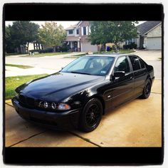 a black car parked in front of a house