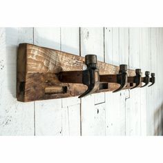 a coat rack made out of wooden planks with metal hooks hanging on the wall