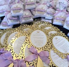 there are many wedding favors in the box on this table with purple ribbons and bows