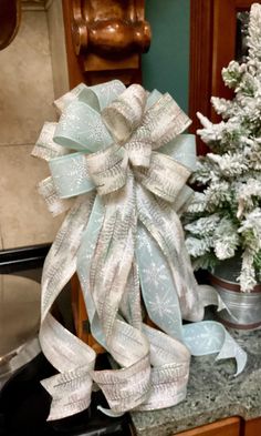 a christmas tree and other decorations on a kitchen counter with a bow in the middle