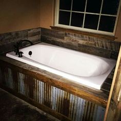 a bath tub sitting next to a window in a bathroom