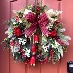 a wreath on the front door decorated with red, white and green decorations