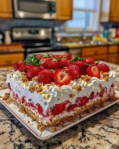 a cake with strawberries on top is sitting on a counter