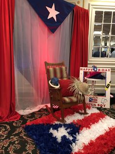 an american flag rug and rocking chair in front of a red white and blue curtain