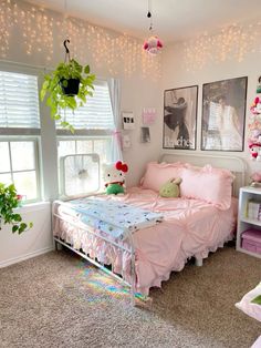 a bedroom with pink bedding and hanging plants