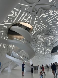 people are walking around in the lobby of a building with intricately designed ceilings and spiral staircases