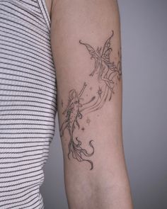 a woman's arm with a tattoo on it that has a little fairy flying through the sky