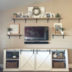 there is a tv on the wall and some shelves above it in this living room