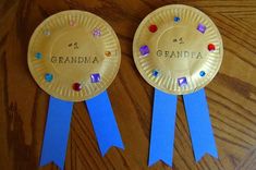 two paper plates with blue ribbons and the words grandpa written on them are sitting on a wooden table