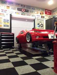 an overhead view of a red sports car parked in a showroom with black and white checkered flooring