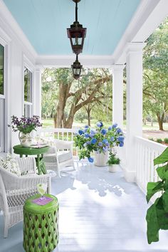 a porch with white wicker furniture and blue ceiling