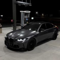 a grey car parked in front of a gas pump