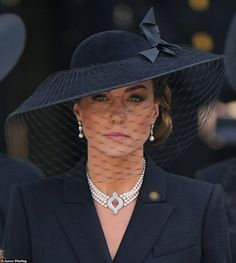 a woman wearing a black hat with a veil on it