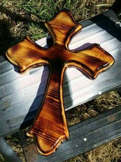 a wooden cross sitting on top of a metal bench