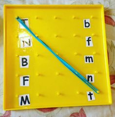 a yellow tray that has letters and numbers on it with a blue needle in the middle