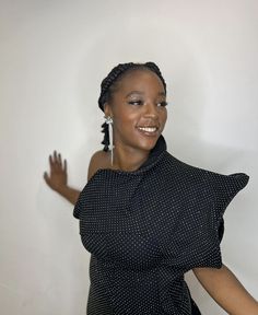 a woman in a black and white polka dot dress with her arms out to the side