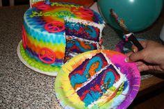 someone is decorating a tie dye cake with peace signs on the top and sides