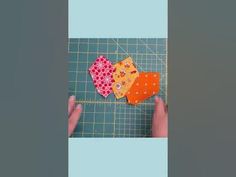 someone is cutting out two hearts on a piece of paper and then using scissors to sew them together