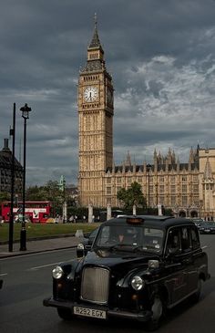 a black taxi driving past big ben in london