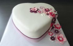 a heart shaped cake with flowers on it