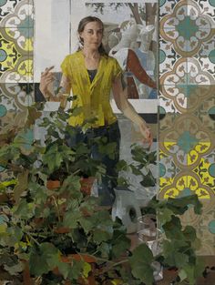 a woman standing in front of a mirror next to a potted plant with green leaves on it