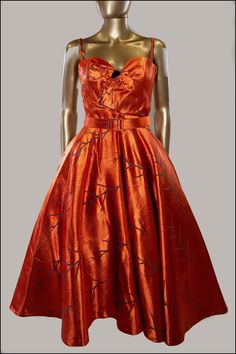 "A one of a kind cocktail dress created in a vintage burnt amber orange satin.  Designed with a hand draped sweetheart bodice, fine straps and internal bodice for support. Cinched at the waist with a matching wide belt and featuring a very full circle skirt with hidden pockets.  Patterned all over with a mid century twig design that contrasts with the spectacular amber colour which appears like fire in the light.  Fine straps boned sweetheart bodice belted waist full circle skirt fully lined hidden pockets one of a kind piece size can be altered to 2\" larger or smaller upon request. Fabrics:  vintage 1950s heavy satin brocade cotton silk mix Lined in cotton and rayon satin Colour: burnt orange, fire, amber, spice, pumpkin Care: dry clean and spot clean only. Do not machine wash. Size: Sma Dresses 1950s Style, Satin Belt, Orange Satin, Full Circle Skirt, 1950s Style, Brown Velvet, Full Circle Skirts, Vintage Glam, Skirt Midi