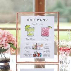 a bar menu sitting on top of a table next to vases filled with flowers