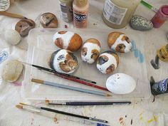 several small stuffed animals sitting on top of a plastic tray with paint and other supplies