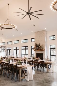 a large room with tables and chairs set up for a formal function in front of windows