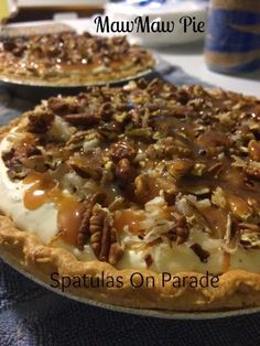 two pies with pecans and other toppings on them sitting on a table