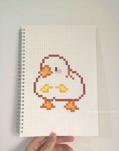 a hand holding up a notebook with an image of a chicken on it