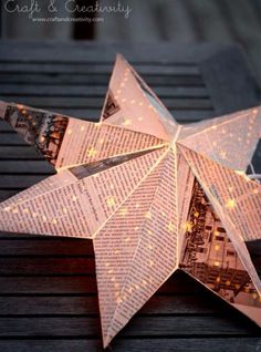 an origami star is lit up with fairy lights