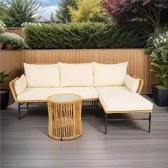 a white couch sitting on top of a hard wood floor next to potted plants