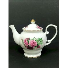 a white tea pot with pink flowers painted on the side and gold trimmings