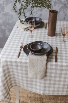 the table is set with black plates and silverware