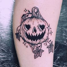 a black and white pumpkin tattoo on the leg