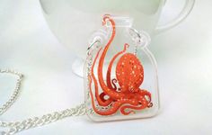 an orange octopus in a glass case on a chain