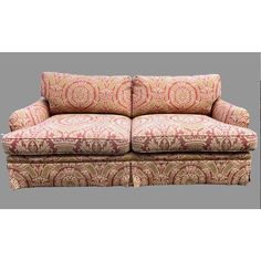 a couch that is sitting in front of a gray background with an ornate pattern on it