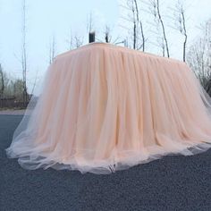 a tulle covered table sitting on the side of a road