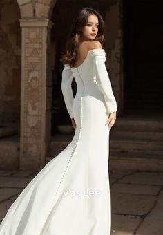 a woman in a white wedding dress posing for the camera with her hands on her hips