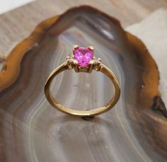 RG496 Pink sapphire-diamond ring. Delicate three stone 14k yellow gold ring mounting set with vivid pink sapphire diamonds. Center stone is .83ct, 6mmx4.2mm, rectangular brilliant cut, intense deep pink - a very sweet stone. Accent stones are 1.7mm round brilliant cut diamonds, SI clarity, G-H color. Would make a beautiful engagement ring. Currently the ring is size 6, will resize at no extra charge, please specify ring size at checkout. Gold Pink Sapphire Ring With Accent Stones, Yellow Gold Pink Sapphire Ring With Center Stone, Gold Sapphire Ring With Pink Sapphire Accent Stones, Yellow Gold Ring With Pink Sapphire Center Stone, Gold Sapphire Ring With Accent Stones, Pink Sapphire Three-stone Jewelry, Pink Three-stone Sapphire Jewelry, Pink Sapphire Three Stone Jewelry, Gold Pink Sapphire Ring With Brilliant Cut