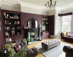 a living room filled with furniture and a fire place in the middle of a room